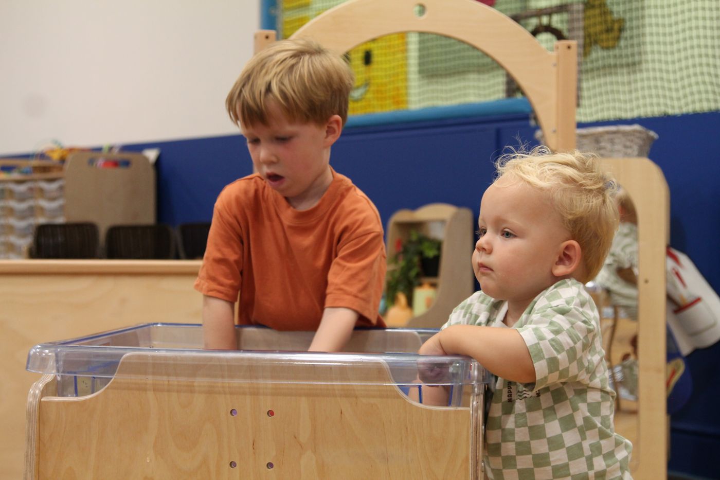 Two children exploring a discovery tub together