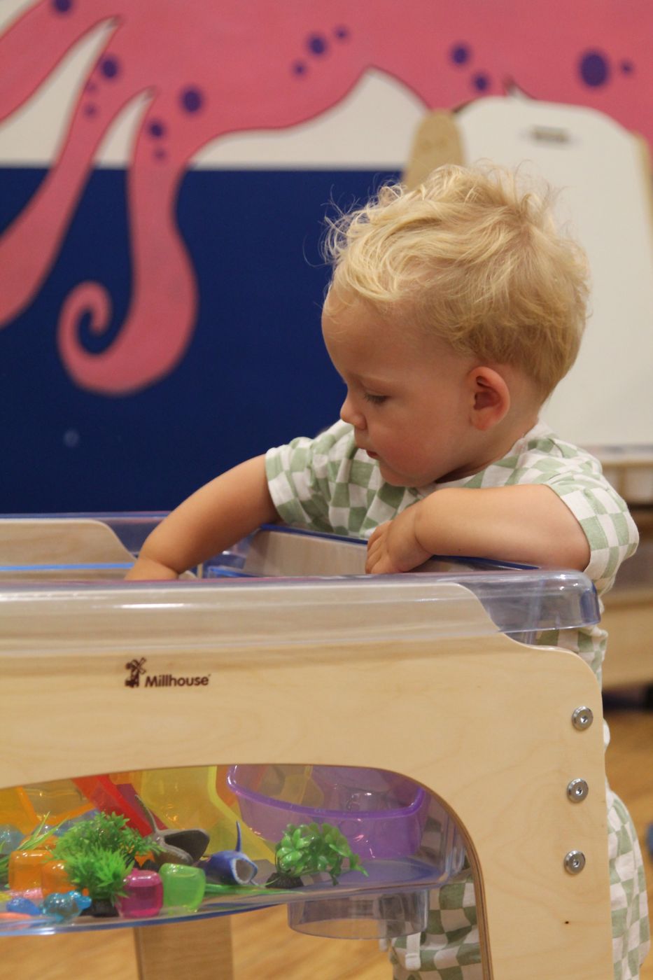 Toddler investigating a discovery tub
